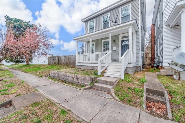 view of front of home featuring a porch and fence