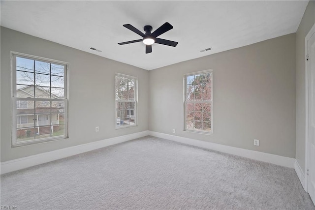 unfurnished room featuring carpet flooring, plenty of natural light, a ceiling fan, and baseboards