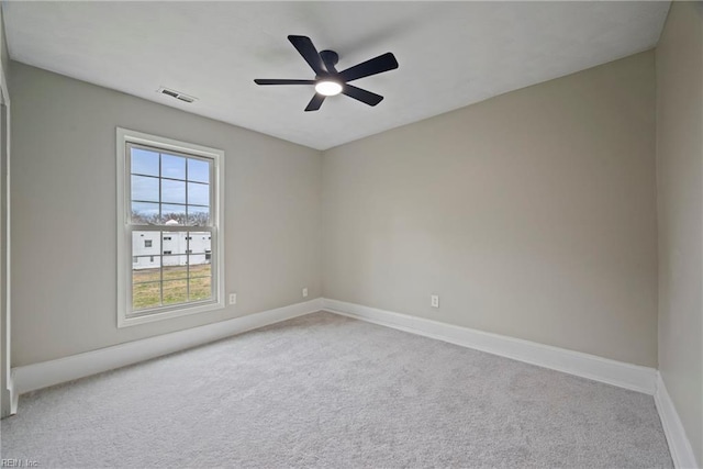 empty room with visible vents, baseboards, carpet, and a ceiling fan