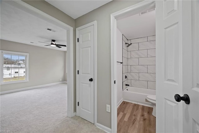 bathroom with visible vents, bathtub / shower combination, toilet, and baseboards