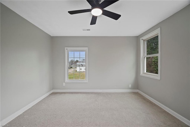 unfurnished room featuring visible vents, baseboards, carpet, and ceiling fan