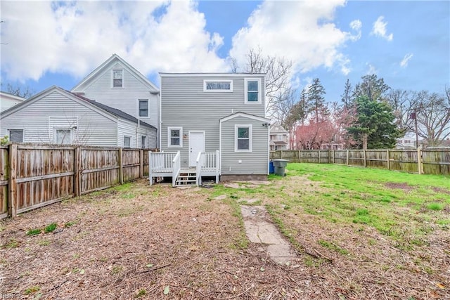 rear view of property with a fenced backyard, a lawn, and a wooden deck