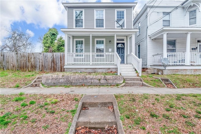 view of front of house featuring fence and covered porch