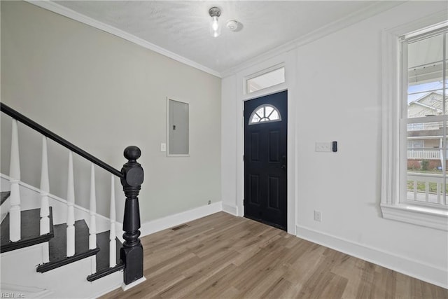 entrance foyer featuring visible vents, crown molding, baseboards, electric panel, and wood finished floors