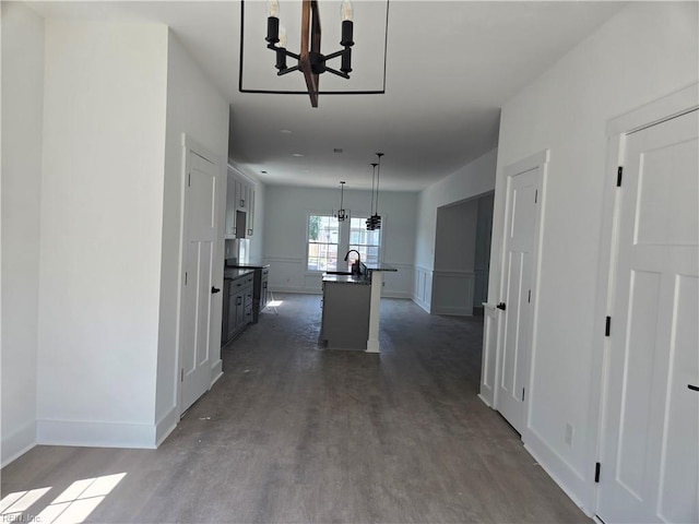 2514 Oak Ave, Newport News, VA 23607 - kitchen with a chandelier, dark countertops, dark wood-style floors, an island with sink, and baseboards