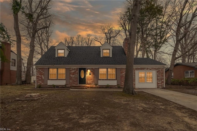 cape cod house with brick siding, concrete driveway, and roof with shingles