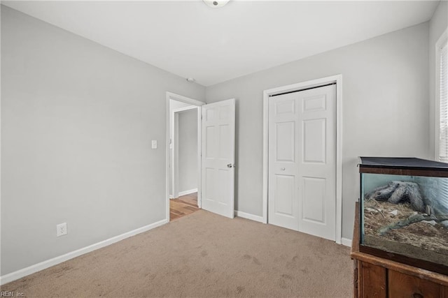 bedroom featuring a closet, baseboards, and carpet flooring