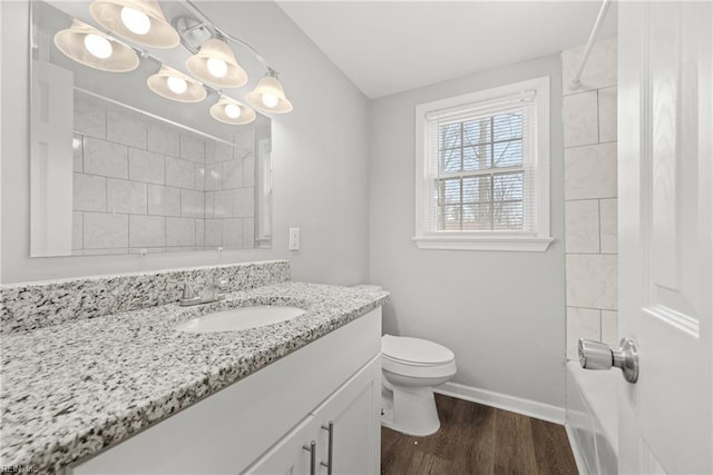 bathroom with toilet, wood finished floors, a shower, baseboards, and vanity