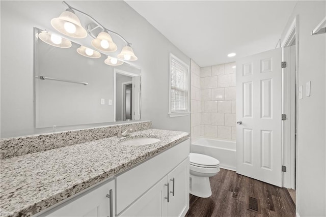 bathroom featuring visible vents, toilet, bathing tub / shower combination, wood finished floors, and vanity