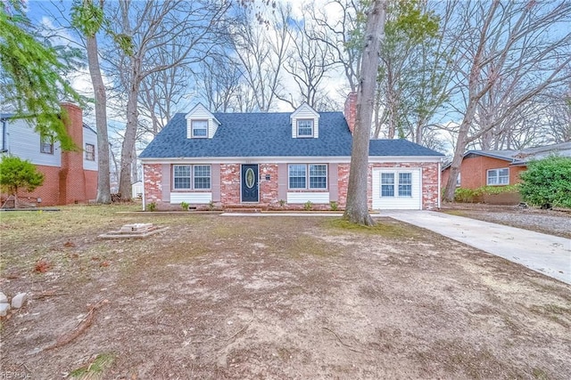 cape cod-style house with a chimney, brick siding, driveway, and roof with shingles