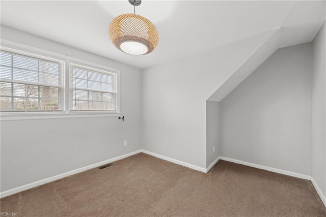 additional living space featuring visible vents, baseboards, carpet, and lofted ceiling