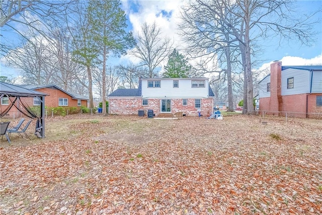 rear view of property with a gazebo and fence