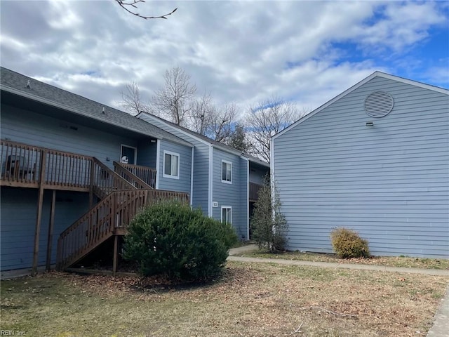 view of side of property featuring stairway and a wooden deck