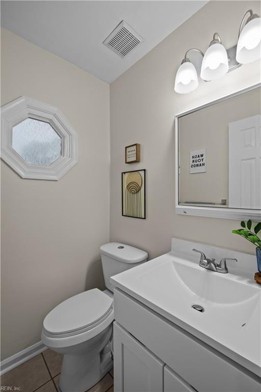 bathroom with toilet, vanity, tile patterned flooring, and visible vents