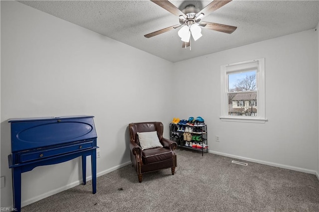 living area featuring a textured ceiling, baseboards, and carpet flooring