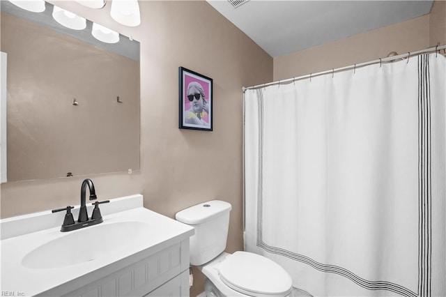 bathroom featuring toilet, visible vents, a shower with shower curtain, and vanity