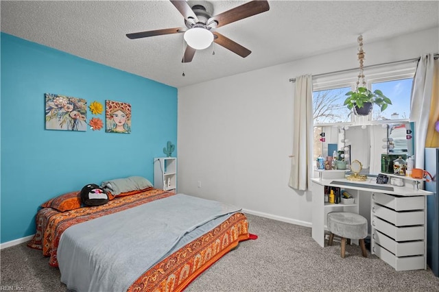 carpeted bedroom with ceiling fan, baseboards, and a textured ceiling