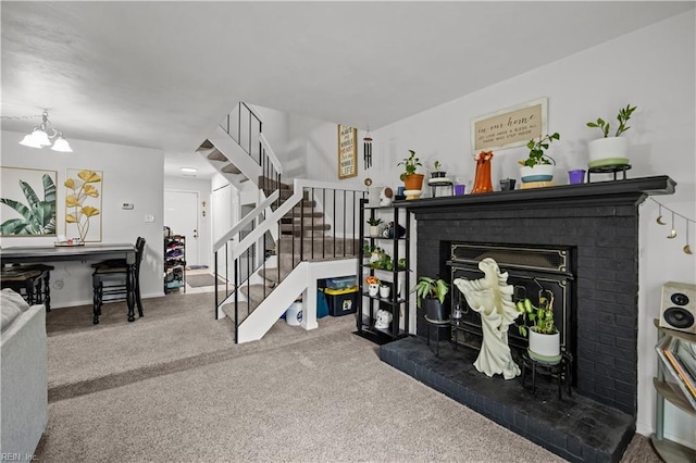 living room featuring carpet floors, a fireplace, stairway, and baseboards