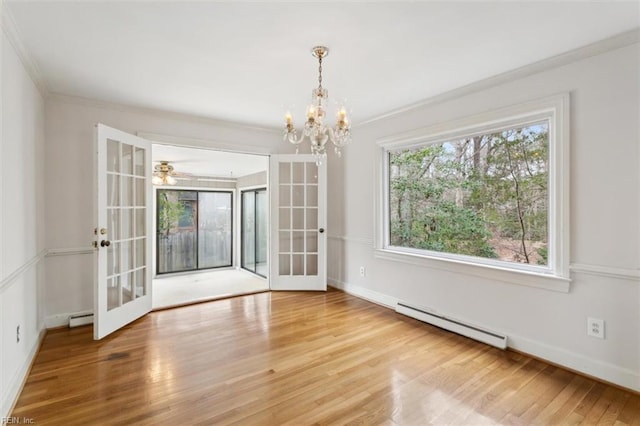 unfurnished dining area featuring crown molding, a baseboard heating unit, wood finished floors, and french doors