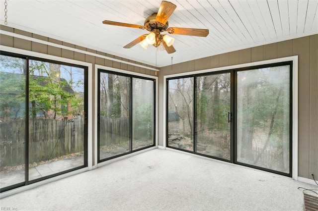 unfurnished sunroom featuring a ceiling fan