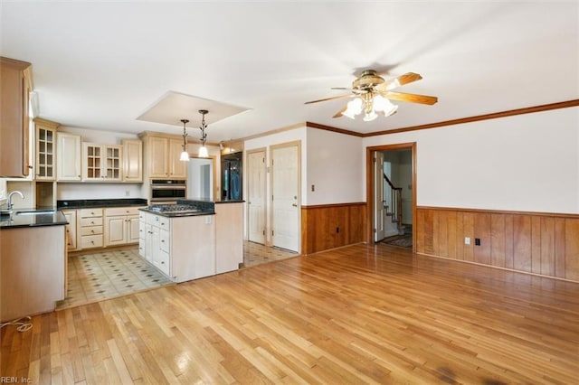 kitchen featuring light wood-style flooring, wainscoting, a kitchen island, and stainless steel oven