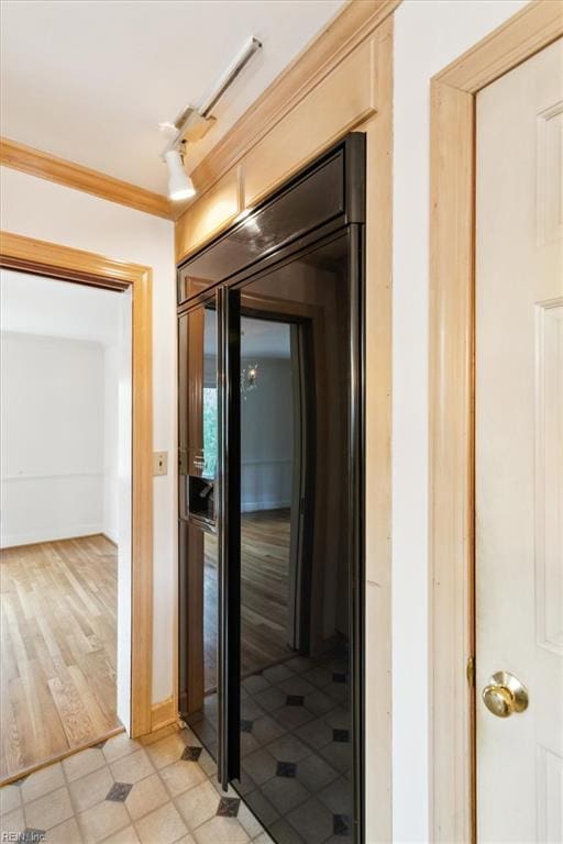 hallway with ornamental molding, track lighting, and baseboards