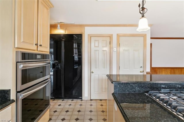 kitchen featuring dark stone counters, pendant lighting, stainless steel appliances, and light brown cabinetry