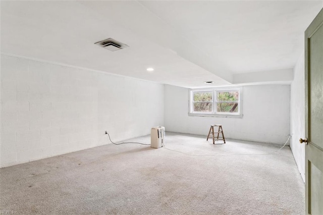 bonus room with carpet flooring and concrete block wall