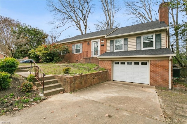 single story home with a shingled roof, concrete driveway, a chimney, an attached garage, and brick siding