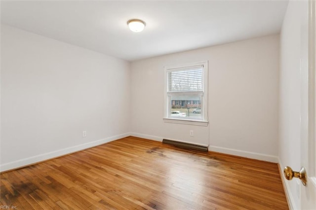 empty room featuring visible vents, baseboards, and wood finished floors