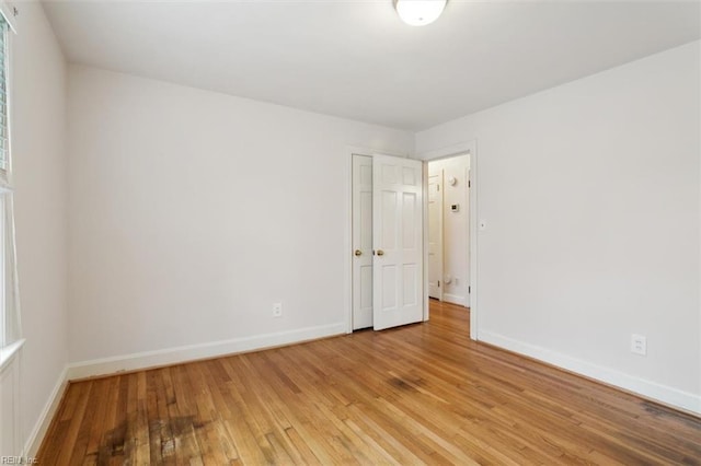 empty room featuring light wood finished floors and baseboards