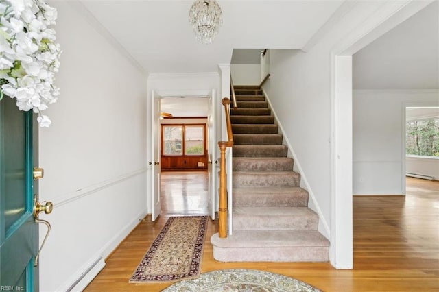 foyer entrance featuring light wood-style floors, stairs, and ornamental molding