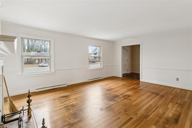 unfurnished room featuring a baseboard heating unit, baseboards, and wood finished floors