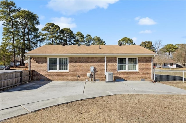 back of house featuring a patio, brick siding, fence, and central air condition unit