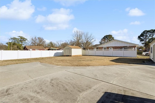 view of yard with an outbuilding, a fenced backyard, and a shed