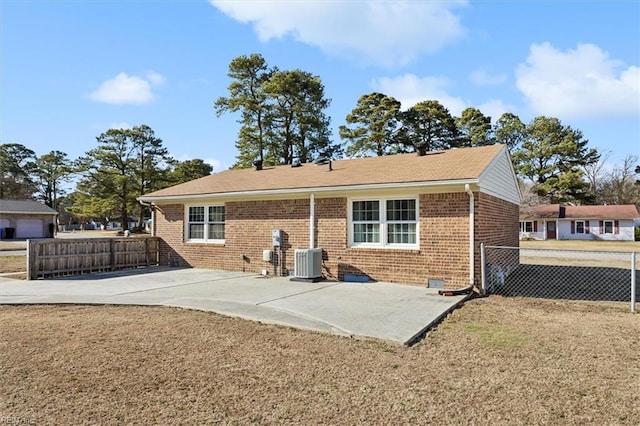 rear view of property featuring a patio, brick siding, cooling unit, and fence