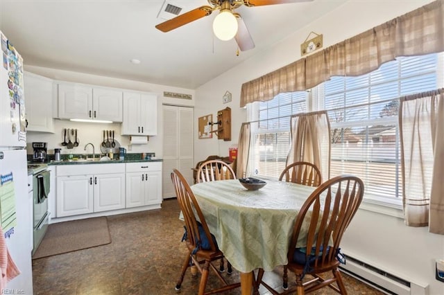 dining room with a baseboard heating unit, visible vents, and a ceiling fan