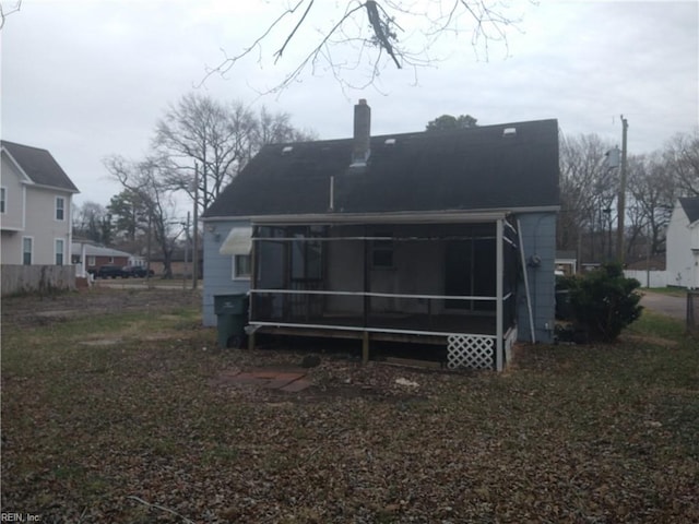 back of house with a sunroom and a chimney