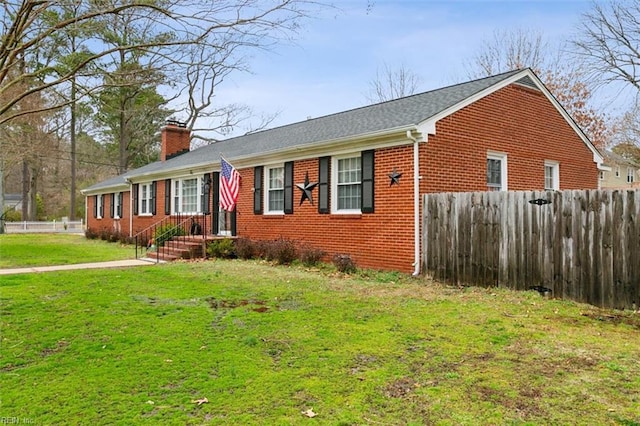 ranch-style house featuring a front yard, brick siding, fence, and a chimney