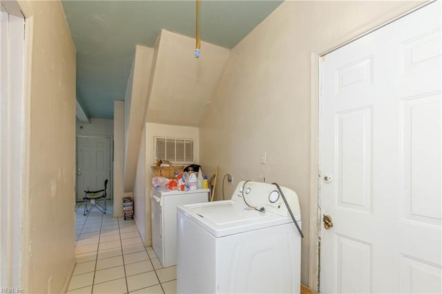 washroom featuring laundry area, light tile patterned floors, visible vents, and washing machine and clothes dryer