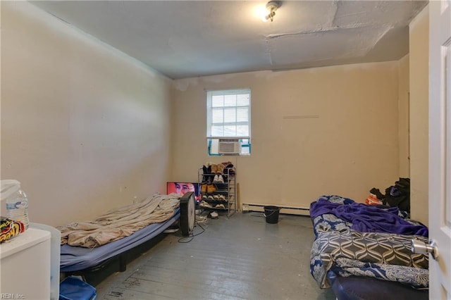 bedroom with baseboard heating and wood-type flooring