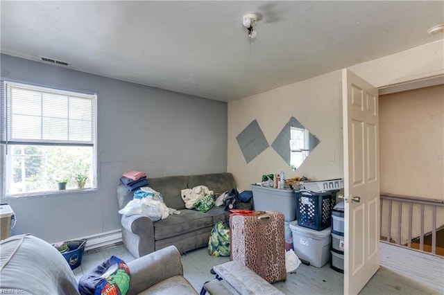 living area with visible vents and wood finished floors