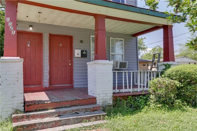 entrance to property with a porch and cooling unit