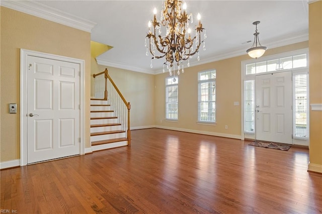 foyer featuring baseboards, stairway, wood finished floors, and ornamental molding