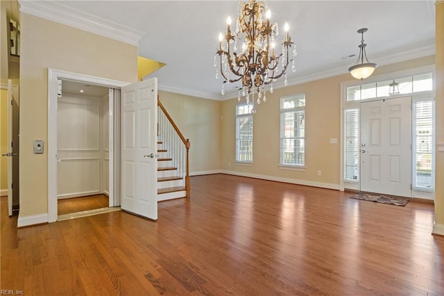 foyer entrance featuring ornamental molding, stairway, baseboards, and wood finished floors