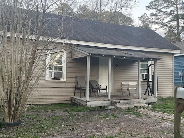 view of front facade with roof with shingles and cooling unit