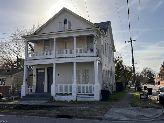 view of front of house featuring a balcony, covered porch, and roof with shingles