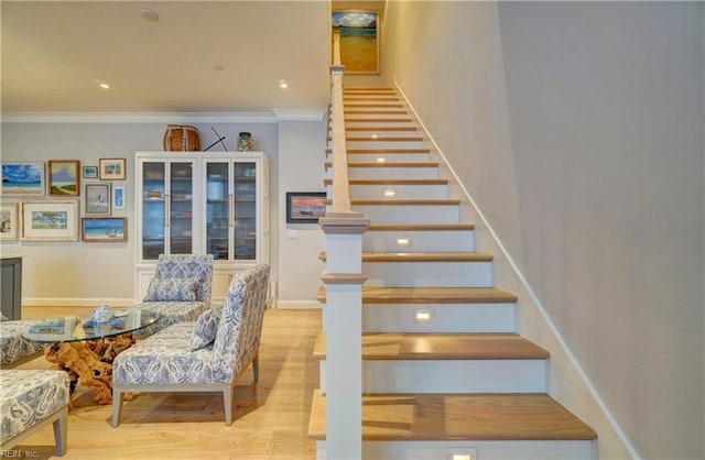 stairs featuring baseboards, wood finished floors, and crown molding