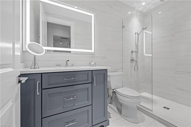 full bathroom featuring vanity, toilet, marble finish floor, and tiled shower