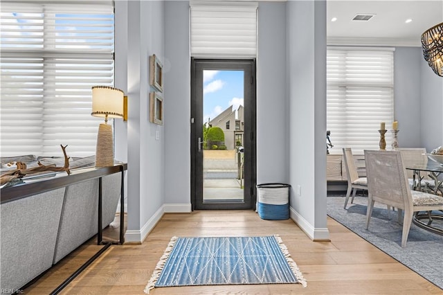 entrance foyer featuring visible vents, crown molding, baseboards, light wood-type flooring, and recessed lighting